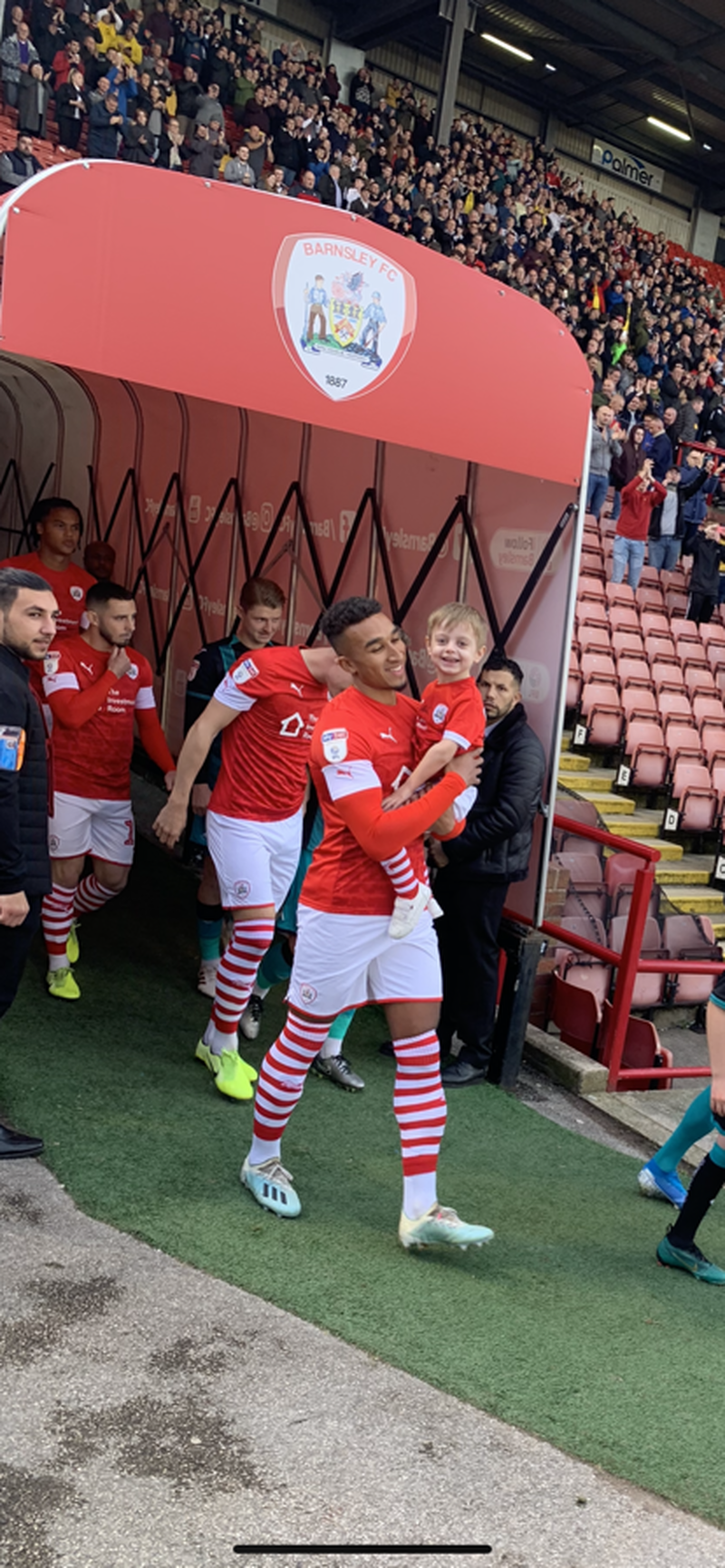 FOOTBALLING HERO: Jacob carrying Jack onto the pitch at Oakwell in 2019.