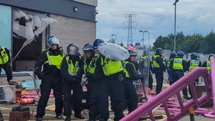 An injured police officer is helped during the disorder at Manvers on August 4.