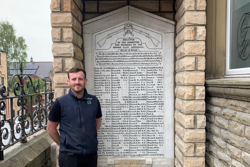 AWARD: Peter Harper with the war memorial.