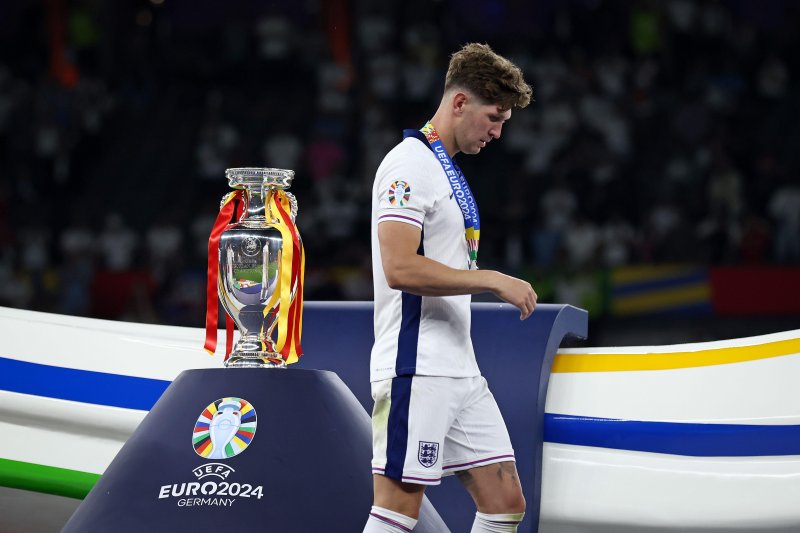 So close: John Stones walks past the trophy after receiving his runners-up medal in Berlin on Sunday.  Picture: Alamy.