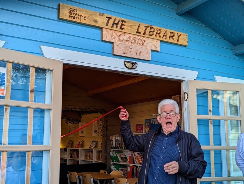 Ian McMillan cutting the ribbon of the new library.