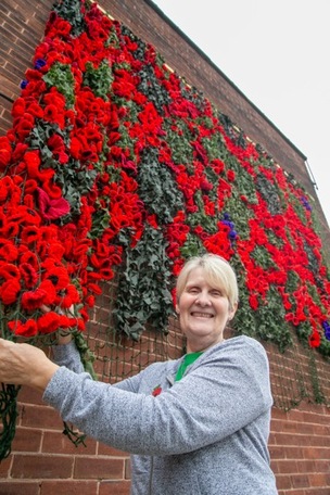 Hand knitted poppies are proudly displayed outside Maggie’s cafe in Monk Bretton, Pictured is owner Maggie Wood Picture Shaun Colborn PD093645